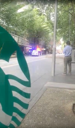 A police officer intervenes near the Bourke Street mall, in Melbourne, Australia, November 9, 2018 in this picture grab obtained from social media video. VIKY CHEN/via REUTERS