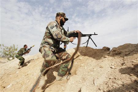 Shi'ite fighters, fighting along forces loyal to Syria's President Bashar al-Assad, take up position on the front line near the Sayyede Zinab area in Damascus November 22, 2013. REUTERS/ Alaa Al-Marjani