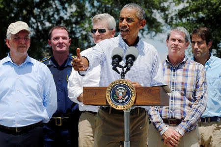 U.S. President Barack Obama (C), flanked by elected officials including Louisiana Governor John Bel Edwards (L) delivers remarks after touring a flood-affected neighborhood in Zachary, Louisiana, U.S. August 23, 2016. REUTERS/Jonathan Ernst