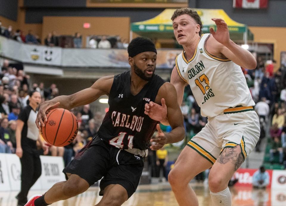 University of Alberta's Adam Paige, right, defends a Carleton player during the U Sports Men's Final 8 Basketball Championship in Edmonton in 2022. Paige is now in his fifth year with the Golden Bears. (Jason Franson/The Canadian Press/File - image credit)