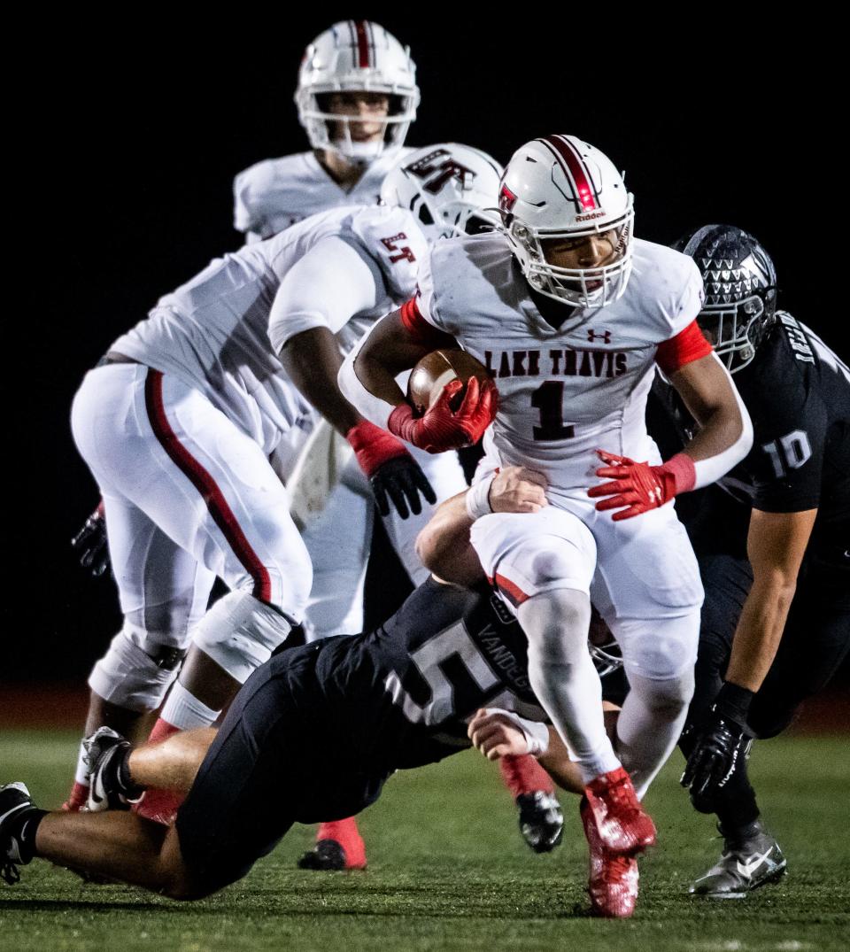 Lake Travis running back Nico Hamilton carries the ball away from the Vandegrift defense during a playoff game at Vandegrift High School on Friday night. Lake Travis won the game 13-10, knocking Vandegrift out of the running for a state title.