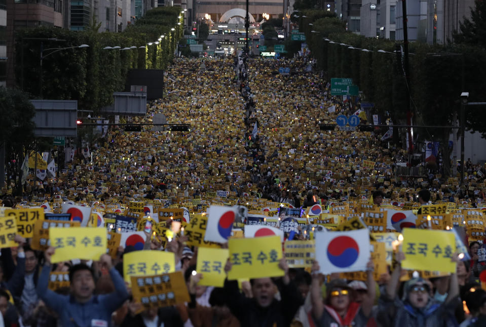 Supporters of South Korea's Justice Minister Cho Kuk shout slogans as they hold banners during a rally near Seoul Central District Prosecutors' Office in Seoul, South Korea, Saturday, Oct. 5, 2019. The letters read "Protect Cho Kuk". (AP Photo/Lee Jin-man)