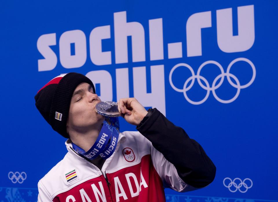 Men's moguls silver medalist Mikael Kingsbury of Canada kisses his medal at the 2014 Winter Olympics, Tuesday, Feb. 11, 2014, in Sochi, Russia. (AP Photo/Adrian Wyld)