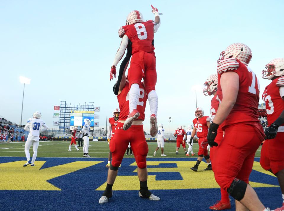 Smyrna's Yamir Knight gets a lift from Nathaniel Chandler after Knight scored late in the second quarter against Dover in the DIAA Class 3A championship at Delaware Stadium, Saturday, Dec 10, 2022.