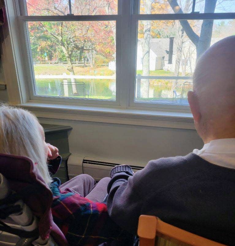 A Sentry Hill resident who lives in assisted living visits his wife in memory care, holding hands as they birdwatch.