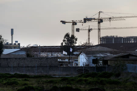 A Greek national flag waves on the wall of an old naval base where the construction of the first formal mosque has started, in Athens, Greece, February 6, 2017. REUTERS/Alkis Konstantinidis