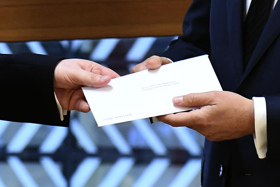 EU Council President Donald Tusk gets British Prime Minister Theresa May's formal notice from UK Permanent Representative to the EU Tim Barrow in Brussels, Wednesday, March 29, 2017. Barrow hand-delivered the letter signed by Britain's Prime Minister Theresa May that will formally trigger the beginning of Britain's exit from the European Union. (Emmanuel Dunand, Pool via AP)