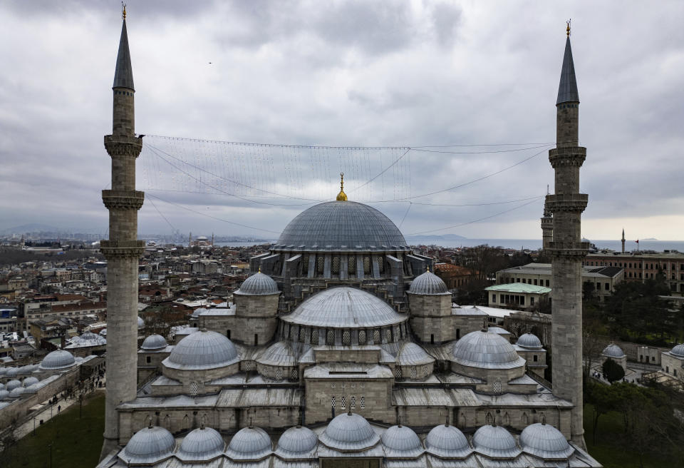 Mahya master Kahraman Yildiz, top left, works in the installation of a lights message at the top of one of the minarets of the Suleymaniye mosque ahead of the Muslim holy month of Ramadan, in Istanbul, Turkey, Wednesday, March 6, 2024. Yildiz, a master of Mahya the unique Turkish tradition of stringing religious messages and designs between minarets, is facing the twilight of a practice deeply ingrained in Turkish culture that is also taken for granted. (AP Photo/Emrah Gurel)