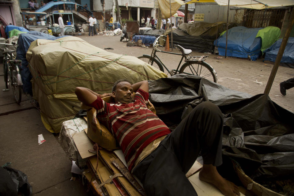 An Indian vendor sleeps at a closed market