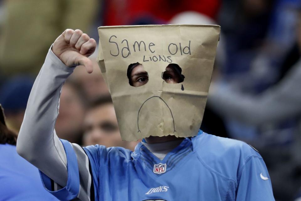 A Detroit Lions fan wears a bag over his head that reads "Same Old Lions."