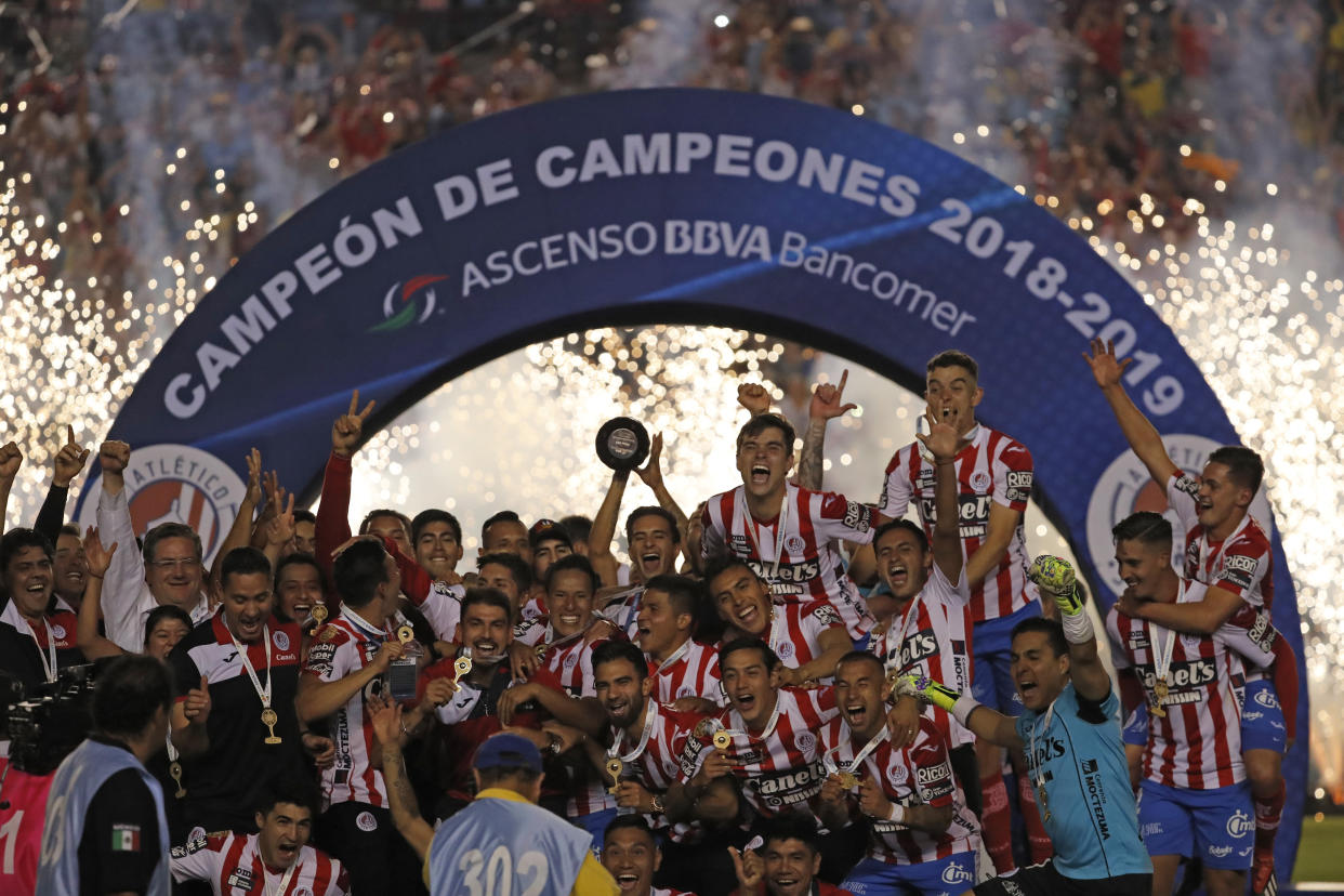 Atletico San Luis players celebrate with the trophy of Mexico's second division soccer league after defeating Dorados in San Luis Potosi, Mexico, Sunday, May 5, 2019. Atletico San Luis won promotion to the Mexican first division soccer league. (AP Photo/Eduardo Verdugo)