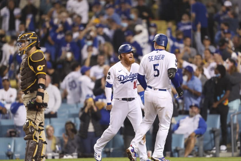 Los Angeles, CA - September 29: Padres catcher Victor Caratini, left, looks away as Dodgers Justin Turner left, and Corey Seager celebrate Seager's game-winning two-run home run in the bottom of the eighth inning against the San Diego Padres at Dodger Stadium in Los Angeles on Wednesday, Sept. 29, 2021. Dogers won 11-9. (Allen J. Schaben / Los Angeles Times)