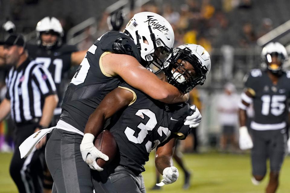 Central Florida running back Trillion Coles (33) celebrates his touchdown against Bethune-Cookman with tight end Zach Marsh-Wojan, left, during the second half of an NCAA college football game, Saturday, Sept. 11, 2021, in Orlando, Fla. (AP Photo/John Raoux)