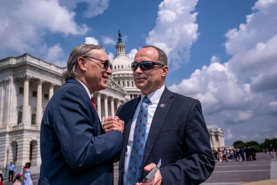 House Freedom Caucus Chair Scott Perry, R-Pa., left, and Rep. Bob Good, R-Va., clasp hands before denouncing the fiscal year 2024 appropriations process and so-called "woke" spending by Democrats and President Joe Biden, at the Capitol in Washington, Tuesday, July 25, 2023.