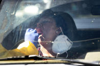 FILE - In this June 20, 2020, file photo, people get tested for COVID-19 at a drive through testing site hosted by the Puente Movement migrant justice organization Saturday in Phoenix. (AP Photo/Matt York, File)