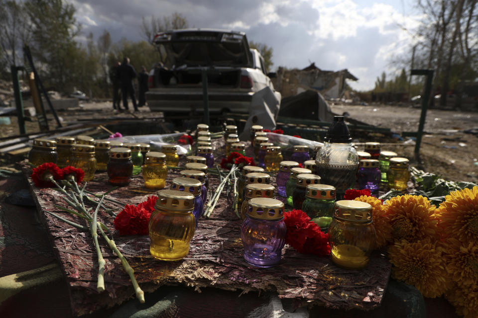 A memorial made with candles and flowers, which were brought by local residents, in the village of Hroza near Kharkiv, Ukraine, Friday, Oct. 6, 2023. Ukrainian officials say at least 51 civilians were killed in a Russian rocket strike on a village store and cafe in the eastern part of the country in one of the deadliest attacks in recent months. (AP Photo/Alex Babenko)