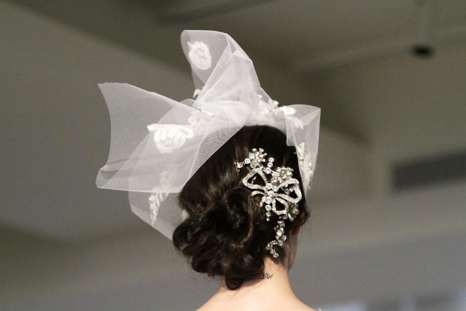 A model presents a bridal fashion creation from the Oscar de la Renta collection, in New York, Monday, April 22, 2013. (AP Photo/Bebeto Matthews)