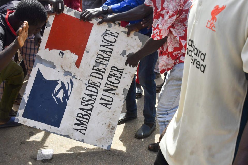 Protesters hold a sign taken from the French Embassy in Niamey, Niger, during a demonstration supporting the junta on July 30, 2023. (AFP - Getty Images)