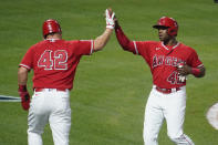 Los Angeles Angels' Justin Upton, right, is high-fived by Mike Trout after they both scored on single from Jared Walsh during the fourth inning of a baseball game against the Minnesota Twins Friday, April 16, 2021, in Anaheim, Calif. (AP Photo/Marcio Jose Sanchez)