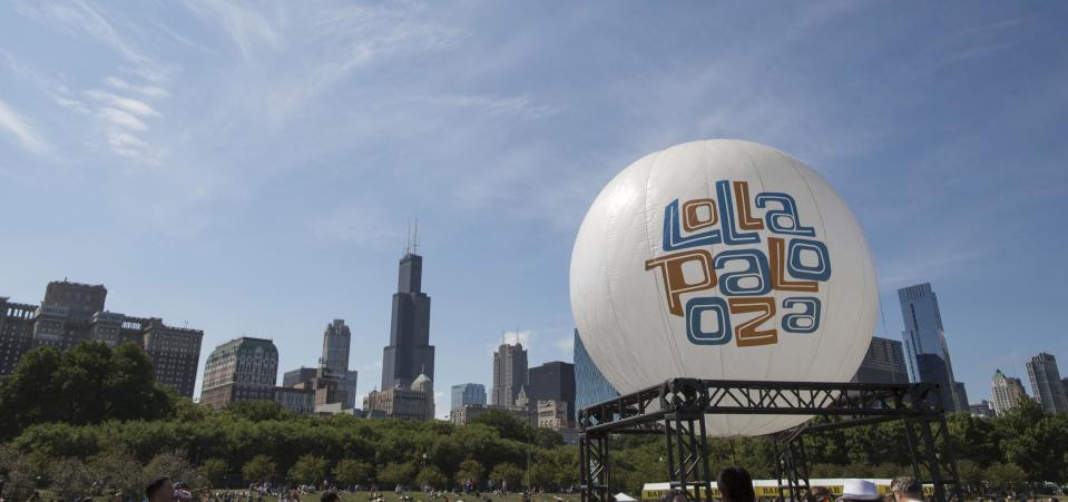 FILE - In a Sunday, Aug. 4, 2013 file photo, a Lollapalooza balloon floats between stages at the Lollapalooza Festival in Chicago. The 2014 season of music festivals is upon us. It’s easy to get caught up in the excitement and spend a bundle, on everything from tickets to accommodations to bottles of water. But with a little foresight, it’s easy to cut down on excess spending and enjoy the music and excitement without breaking the bank. (AP Photo/Scott Eisen, File)