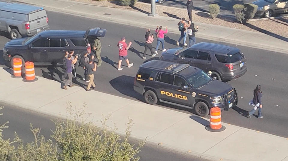 People leave campus with raised hands following reports of a shooting at the University of Nevada campus of Las Vegas, Dec. 6, 2023. / Credit: From video obtained by Reuters