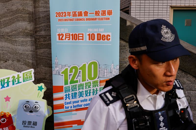 A police stands guard outside a polling station during the District Council election in Hong Kong