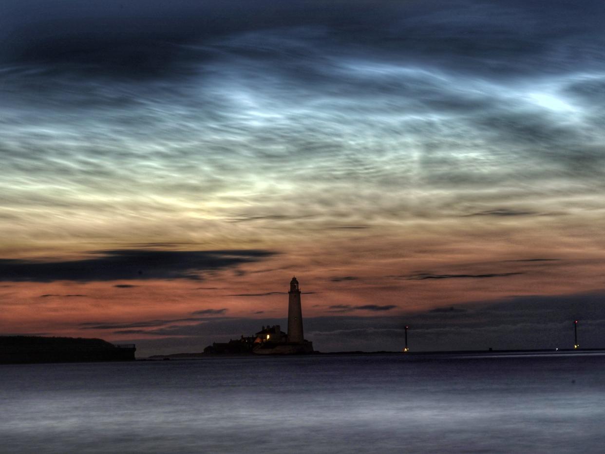 Noctilucent clouds gather over Whitley Bay above St Mary's Lighthouse in England. Image taken June 23rd 2022.