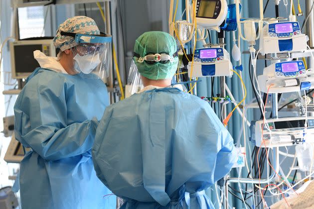 Medical staff members stand in a Covid-19 patient room in the intensive care unit of Cremona hospital, in Cremona, northern Italy, on January 11, 2022. - Italy's Prime Minister Mario Draghi put the pressure back on the unvaccinated on January 10, 2022, calling them the cause of 