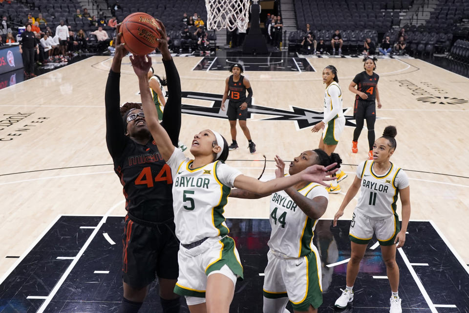 Miami forward Kyla Oldacre (44) and Baylor guard Darianna Littlepage-Buggs (5) reach for a rebound during the first half of an NCAA college basketball game in San Antonio, Saturday, Dec. 16, 2023. (AP Photo/Eric Gay)