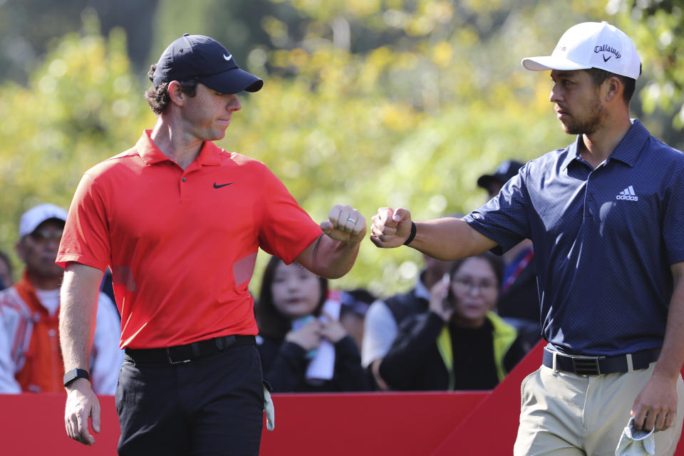 Rory McIlroy of Northern Ireland fist pumps with Xander Schauffele of the United States at right during the HSBC Champions golf tournament held at the Sheshan International Golf Club in Shanghai on Friday, Nov. 1, 2019. (AP Photo/Ng Han Guan)
