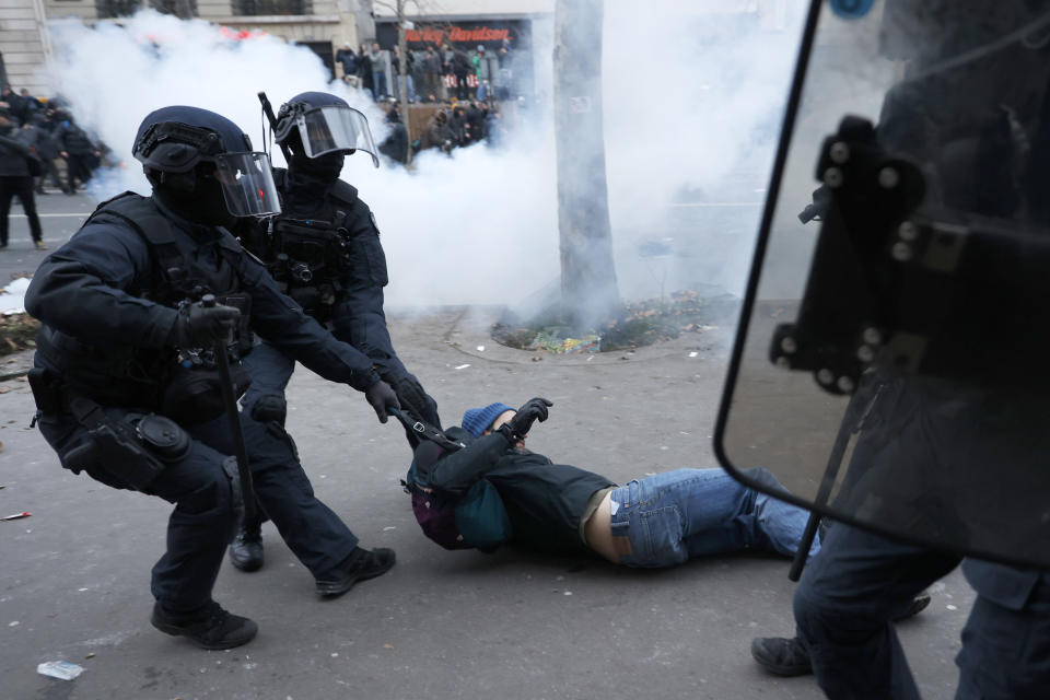 Riot police officers grab a protestor during a demonstration against pension changes, Thursday, Jan. 19, 2023 in Paris. Workers in many French cities took to the streets Thursday to reject proposed pension changes that would push back the retirement age, amid a day of nationwide strikes and protests seen as a major test for Emmanuel Macron and his presidency. (AP Photo/Lewis Joly)