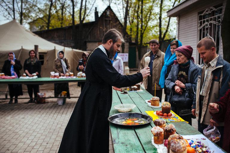 A priest blesses the congregation together with the traditional paschas and eggs they brought during a service outside a church in the eastern Ukrainian city of Lugansk on April 19, 2014