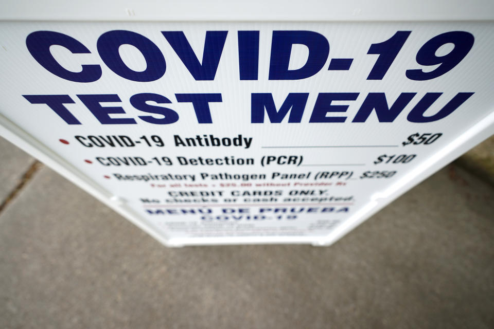 A sign outside Principle Health Systems and SynerGene Laboratory lists COVID-19 tests available Tuesday, April 28, 2020, in Houston. The company, which opened two new testing sites Tuesday, is now offering a new COVID-19 antibody test developed by Abbott Laboratories. (AP Photo/David J. Phillip)