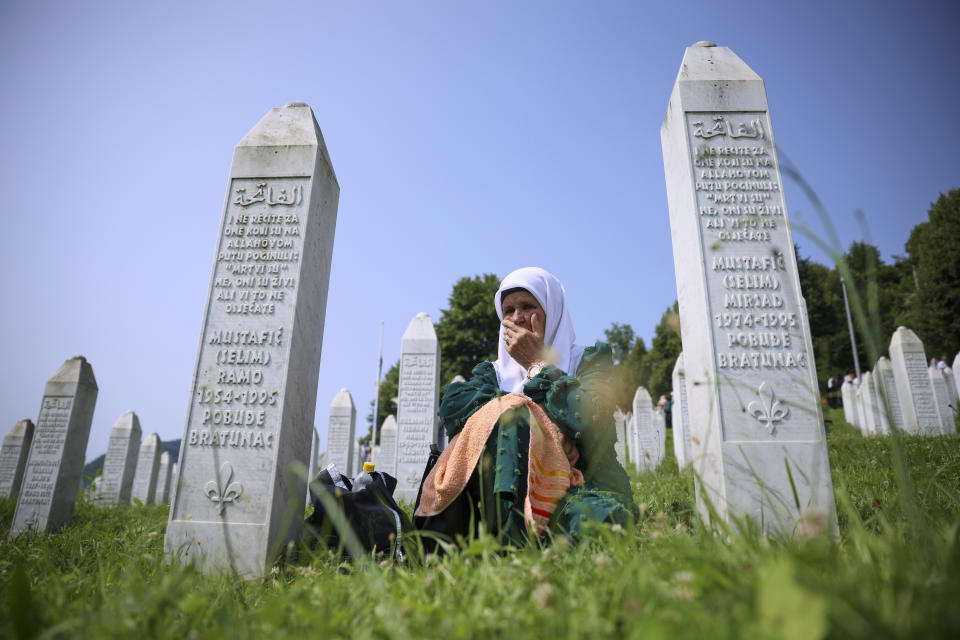 A Bosnian muslim woman mourns next to the grave of her relative, victim of the Srebrenica genocide, in Memorial Centre in Potocari, Bosnia, Tuesday, July 11, 2023. Thousands converge on the eastern Bosnian town of Srebrenica to commemorate the 28th anniversary on Monday of Europe's only acknowledged genocide since World War II. (AP Photo/Armin Durgut)