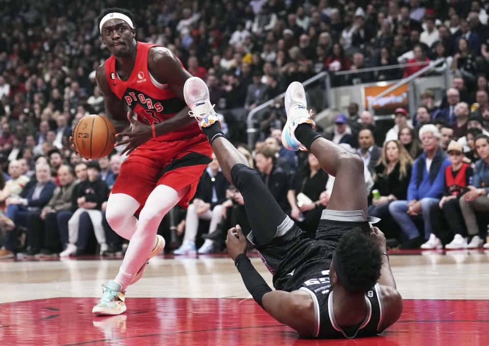 Toronto Raptors forward Pascal Siakam (43) knocks over Sacramento Kings guard Terence Davis (3) during the first half of an NBA basketball game in Toronto on Wednesday, Dec. 14, 2022. (Nathan Denette/The Canadian Press via AP)