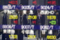 Pedestrian are reflected on an electronic stock board showing Japan's Nikkei 225 index at a securities firm in Tokyo Friday, Dec. 13, 2019. Shares likewise jumped Friday in Asia following fresh all-time highs overnight on Wall Street spurred by optimism that the U.S. and China are close to reaching a deal to end their costly trade war. (AP Photo/Eugene Hoshiko)