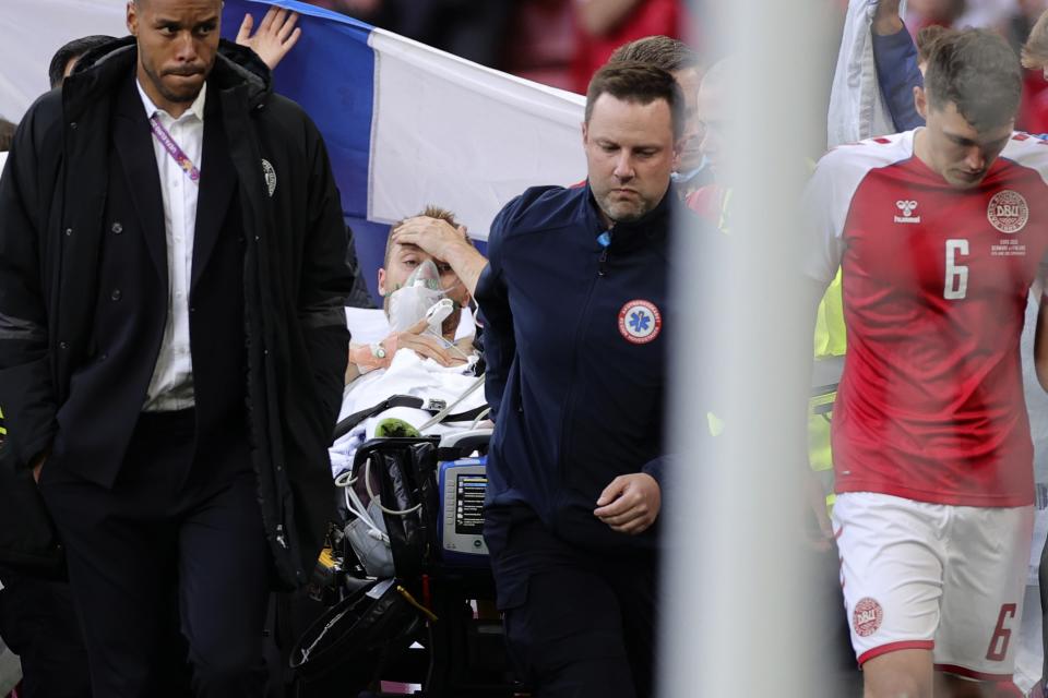 Paramedics using a stretcher to take out of the pitch Denmark's Christian Eriksen after he collapsed during the Euro 2020 soccer championship group B match between Denmark and Finland at Parken stadium in Copenhagen, Denmark, Saturday, June 12, 2021. (Friedemann Vogel/Pool via AP)