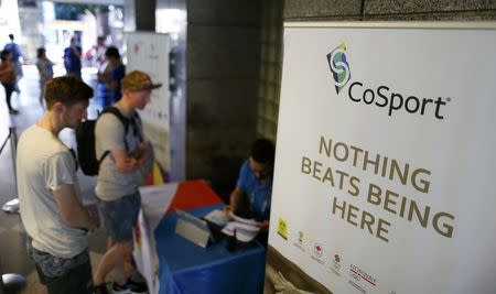 Clients of CoSport, a firm that holds a U.S. Olympic Committee-granted monopoly to sell Rio 2016 events tickets, wait at a booth for information on where to pick up the tickets they purchased online, in Rio de Janeiro August 1, 2016. REUTERS/Ivan Alvarado