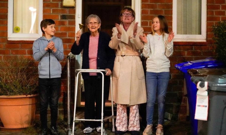 Barbara Leigh, 93, (second left) rings a bell for the NHS, with her family  in Manchester.