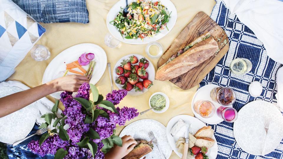 june holidays backyard picnic spread on a yellow blanket for picnic day