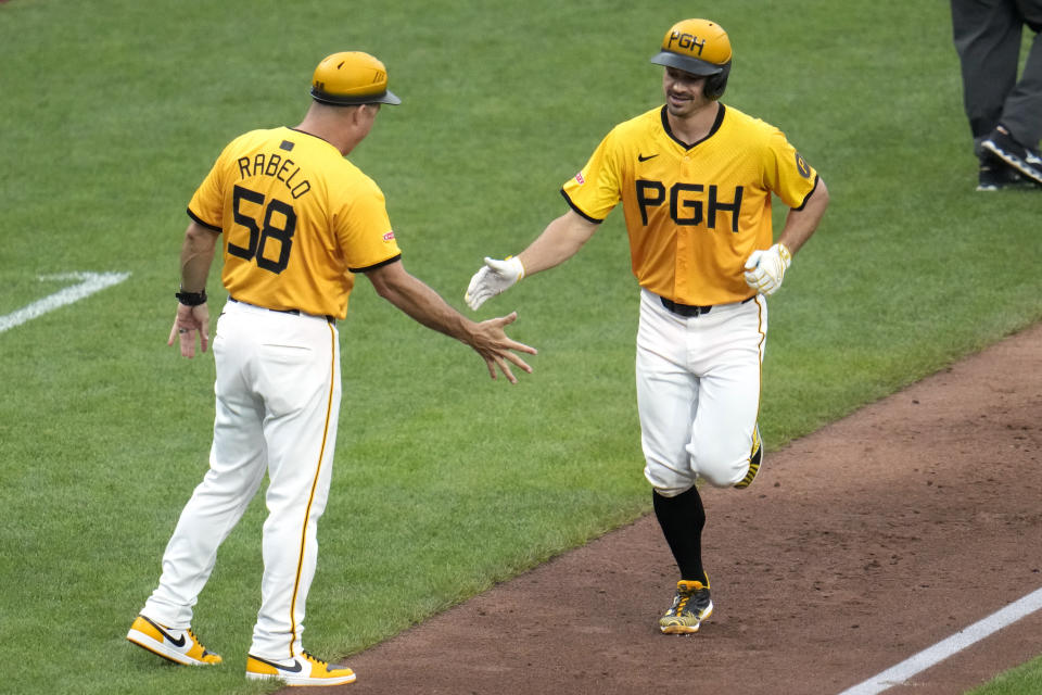 Pittsburgh Pirates' Bryan Reynolds, right, is greeted by third base coach Mike Rabelo (58) as he rounds third base after hitting a grand slam off New York Mets relief pitcher Jake Diekman during the seventh inning of a baseball game in Pittsburgh, Friday, July 5, 2024. (AP Photo/Gene J. Puskar)