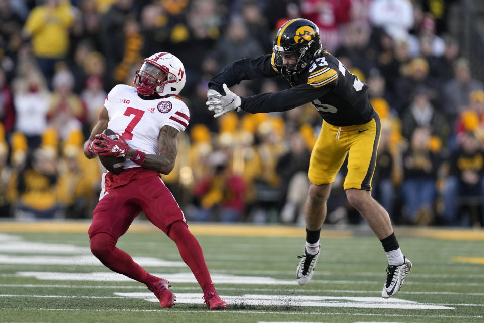Nebraska wide receiver Marcus Washington (7) catches a pass ahead of Iowa defensive back Riley Moss (33) during the first half of an NCAA college football game, Friday, Nov. 25, 2022, in Iowa City, Iowa. (AP Photo/Charlie Neibergall)