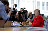 German Chancellor Angela Merkel, right, smiles as she arrives for her annual sommer press conference in Berlin, Germany, Friday, July 19, 2019. (AP Photo/Michael Sohn)