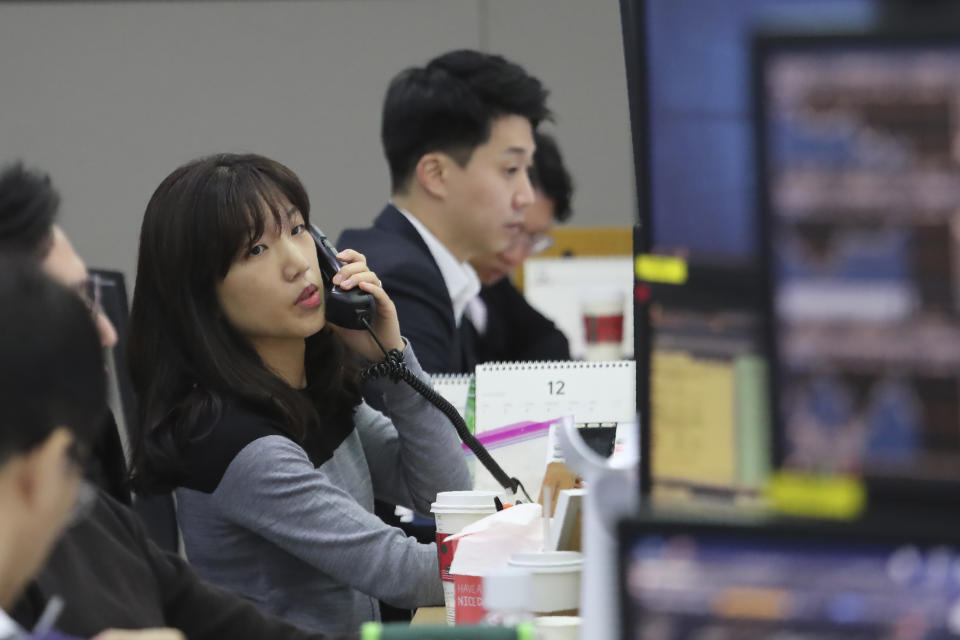 A currency trader talks on the phone at the foreign exchange dealing room of the KEB Hana Bank headquarters in Seoul, South Korea, Monday, Dec. 9, 2019. Asian shares were mostly higher Monday cheered by a buying mood on Wall Street that came at the end of last week. (AP Photo/Ahn Young-joon)