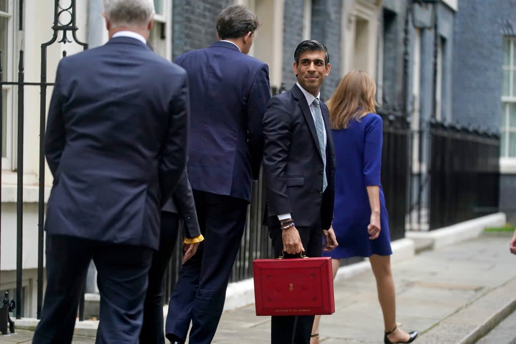 Chancellor Rishi Sunak holds his ministerial ‘Red Box’ as he stands with his ministerial team and parliamentary private secretaries, outside 11 Downing Street (PA) (PA Wire)