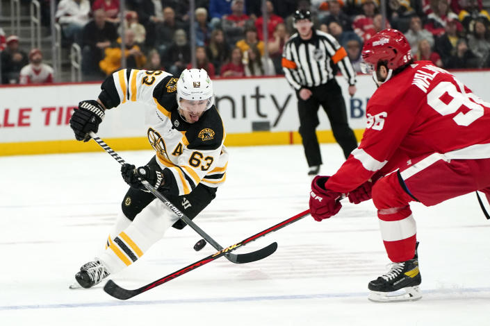 Detroit Red Wings defenseman Jake Walman (96) defends Boston Bruins left wing Brad Marchand (63) in the second period of an NHL hockey game Sunday, March 12, 2023, in Detroit. (AP Photo/Paul Sancya)