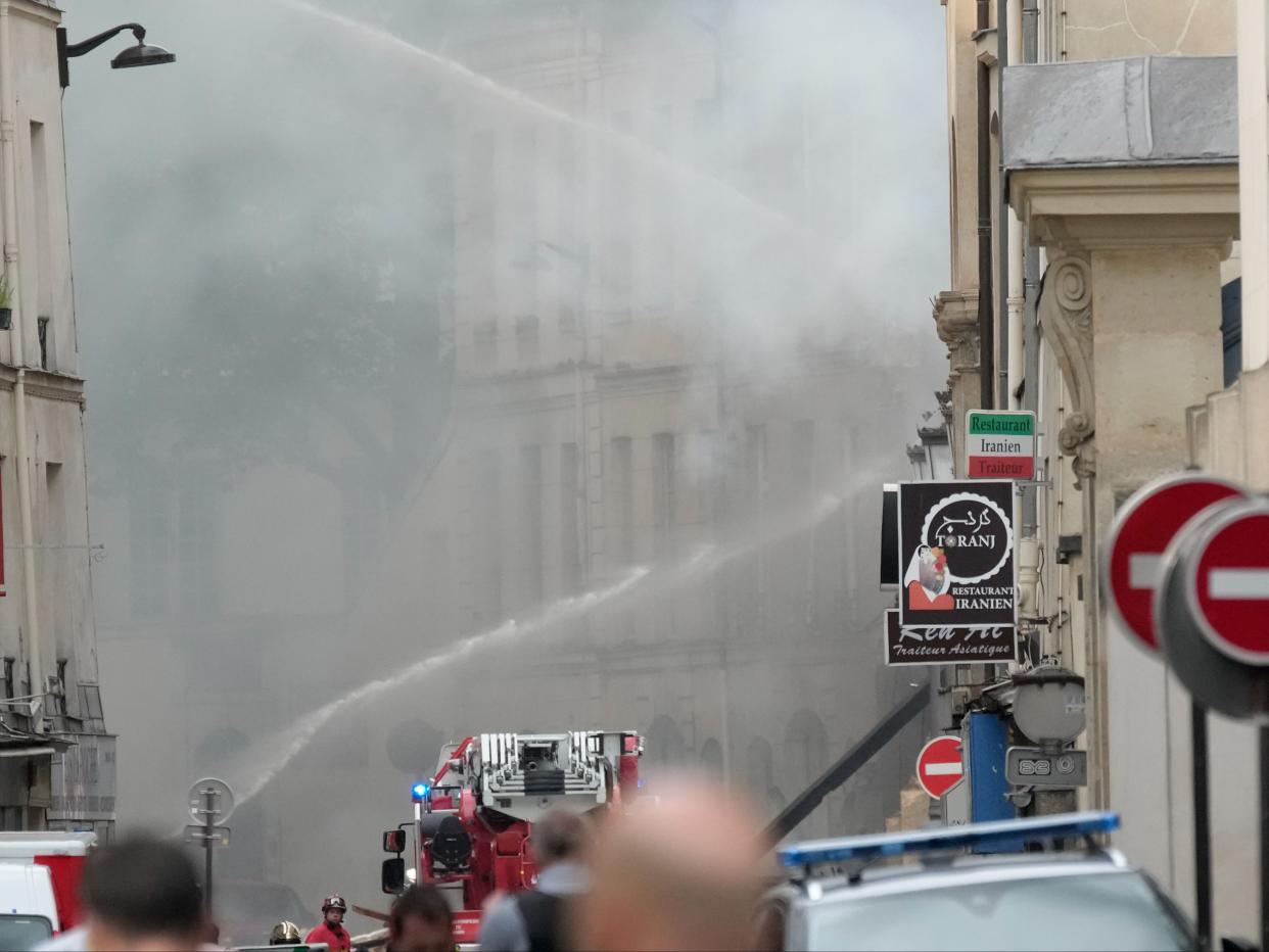 Firemen use a water canon to fight the blaze (AP)