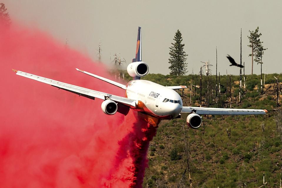 An air tanker drops retardant while trying to stop the Oak Fire from progressing in Mariposa County on Sunday