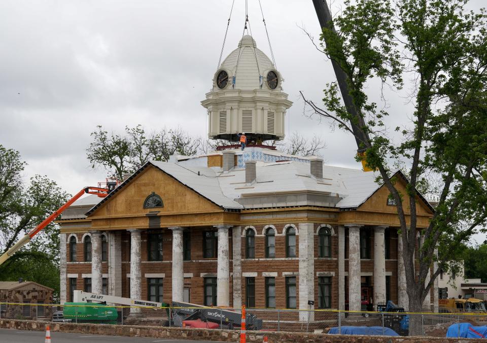 Workers set a new crown on top of the Mason County Courthouse on April 19. Residents lined the town square, which is two blocks in Mason and unusual for Texas, to watch progress made on the courthouse restoration.