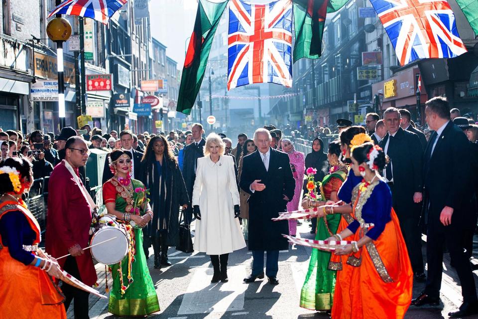 Britain's King Charles III and Britain's Camilla, Queen Consort react during a visit to Brick Lane in east London on February 8, 2023, where they met with representatives from charities and local businesses.
